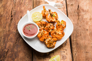 Tandoori Gobi / Roasted cauliflower Tikka is a dry dish made by roasting Cauliflowers in Oven/Tandoor. It's  popular starter food from India. served with ketchup. selective focus