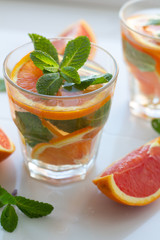 drink with red orange and mint leaves, orange slices close up.