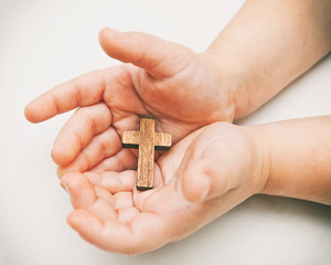 A little wooden cross in the child's hands