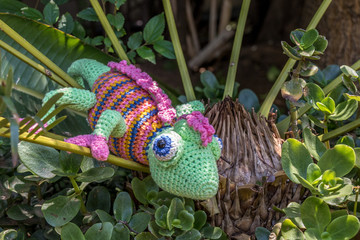 A fake chameleon in a shrub in the garden concept fake image in landscape format with copy space