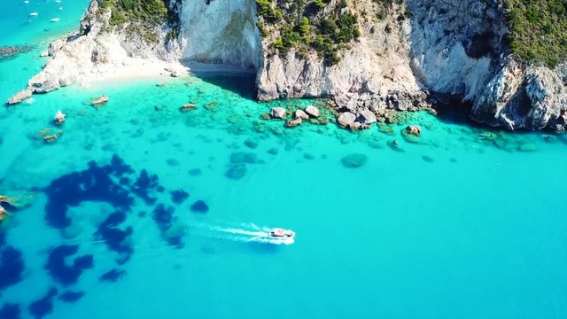 Aerial drone video of small rocky cove and turquoise beach near popular beach of Milos, island of Lefkada, Ionian, Greece