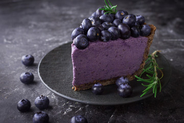 Blueberry vegan cheesecake. Dark photo on black background