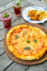 cheese pizza and fresh juices on the wooden table