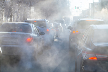 pollution from the exhaust of cars in the city in the winter. Smoke from cars on a cold winter day