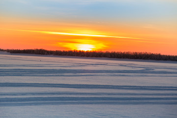 January sunset over a snow covered river