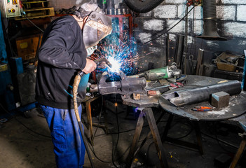 Welder soldering a piece in a factory