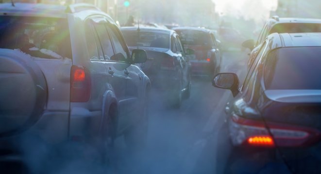 pollution from the exhaust of cars in the city in the winter. Smoke from cars on a cold winter day