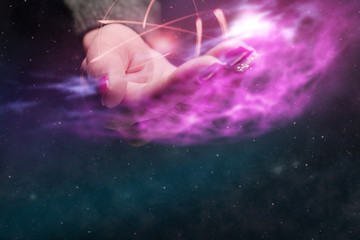 Fototapeta na wymiar Human hand holding atom on a palm. Nebula dust in infinite space. Mixed media.
