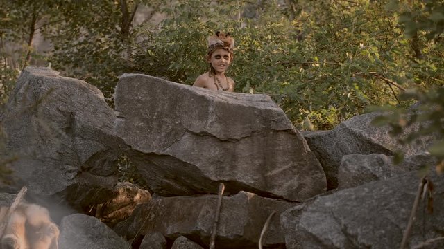 Caveman, manly boy hunting outdoors. Ancient warrior portrait.