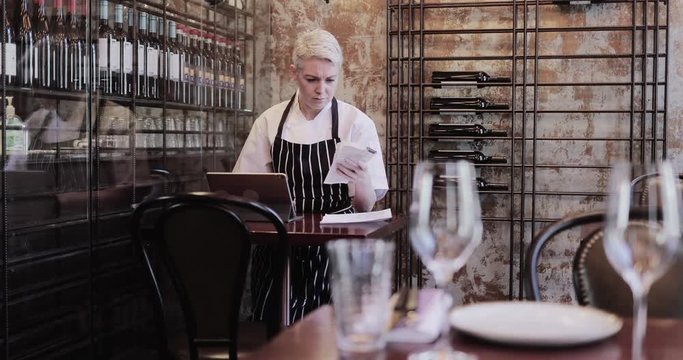 Female chef working on digital tablet in restaurant