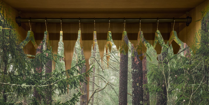 Clothes hanger with dresses in the forest. Concept for organic clothes, closet and sustainable fashion.
