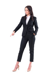 Obraz premium Confident business woman pointing finger down showing empty copy space. Full body isolated on white background. 