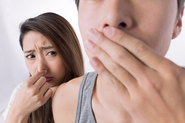 男性の口臭に鼻をつまむ女性