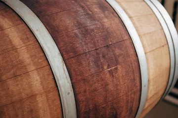 Fotobehang Old wooden wine barrel with iron hoops. © Владимир Никонов