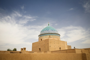 Colorful decorated dome on a medieval clay mud buildings with a blue sky background in Yazd, Iran