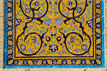Colorful yellow islamic floral decoration art mosaic on a mosque wall in Qom, Iran