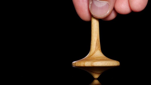 Close up shot of a wooden spinning top moving.