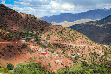 Obraz premium Atlas Mountain landscape in Morocco with a lush green valley, a village with old rock houses and green olive trees, near Ouarzazate