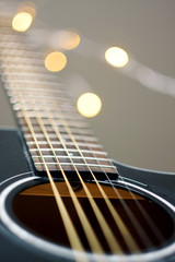 Fototapeta premium fretboard with strings at black glossy guitar with bokeh in the background