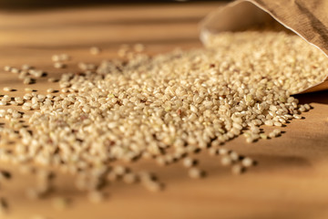 Raw Brown Rice On A wooden table With Bag In The Background. Organic Brown Rice On A table.