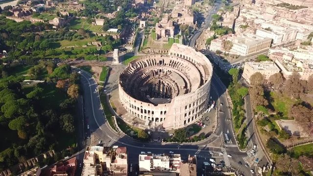 Aerial drone view video of iconic ancient Arena of Colosseum, also known as the Flavian amphitheatre in the heart of Rome next to Roman Forum, Italy