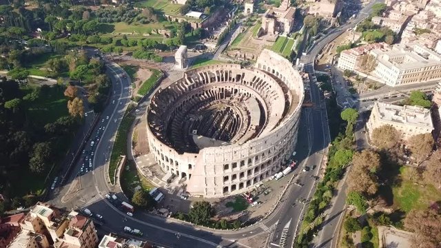 Aerial drone view video of iconic ancient Arena of Colosseum, also known as the Flavian amphitheatre in the heart of Rome next to Roman Forum, Italy