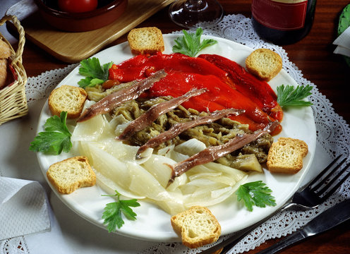 Plato con  verduras al horno pimiento, berenjena, cebolla, tostaditas y anchoas.