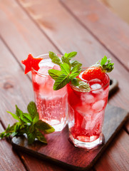 Sparkling pink strawberry lemonade on dark wooden background