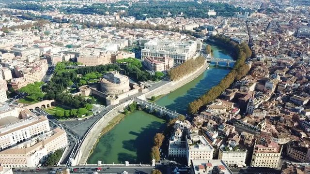 Aerial drone view video of iconic Castel Sant' Angelo (castle of Holy Angel) and Ponte or bridge Sant'Angelo with statues in river of Tiber next to famous Vatican, Rome, Italy