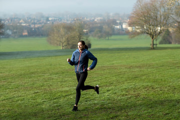 Woman On Early Morning Winter Run Through Park Keeping Fit Through Exercise
