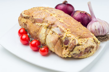 Raw pork with sauce and garnish on white plate.