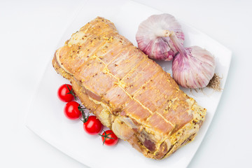 Raw pork with sauce and garnish on white plate.