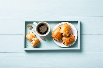 Breakfast with mini fresh croissants bun with chocolate and coffee cup on blue turquoise...