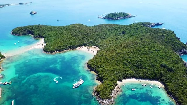 Aerial bird's eye view video taken by drone of boat in tropical paradise seascape of Sivota with turquoise and sapphire clear water sandy beaches, Ionian, Epirus, Greece