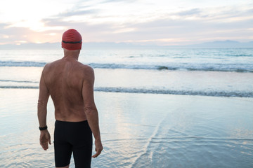 Senior man preparing to swim in the sea at dawn