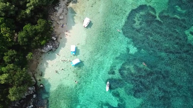 Aerial drone bird's eye view video of famous sandy beach and small island of Agia Paraskevi with emerald clear sea, Sivota, Thesprotia, Epirus, Greece