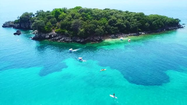Aerial drone bird's eye view video of famous sandy beach and small island of Agia Paraskevi with emerald clear sea, Sivota, Thesprotia, Epirus, Greece