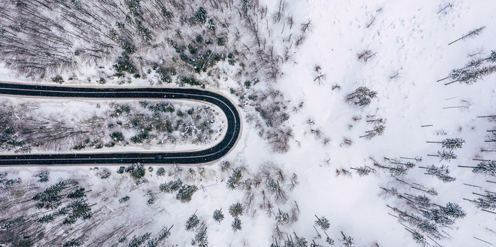 Curvy Windy Road In Snow Covered Forest, Top Down Aerial View. Winter Landscape.