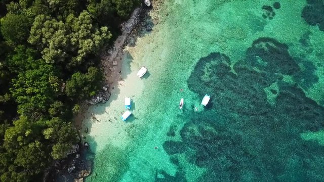 Aerial drone bird's eye view video of famous sandy beach and small island of Agia Paraskevi with emerald clear sea, Sivota, Thesprotia, Epirus, Greece