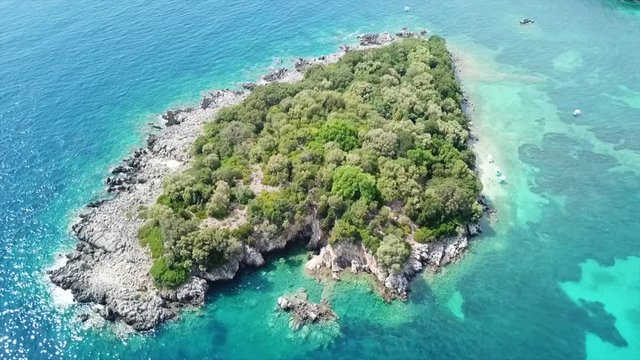 Aerial drone bird's eye view video of famous sandy beach and small island of Agia Paraskevi with emerald clear sea, Sivota, Thesprotia, Epirus, Greece