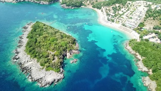 Aerial drone bird's eye view video of famous sandy beach and small island of Agia Paraskevi with emerald clear sea, Sivota, Thesprotia, Epirus, Greece