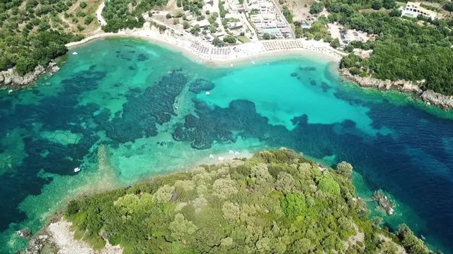 Aerial drone bird's eye view video of famous sandy beach and small island of Agia Paraskevi with emerald clear sea, Sivota, Thesprotia, Epirus, Greece