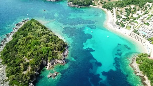 Aerial drone bird's eye view video of famous sandy beach and small island of Agia Paraskevi with emerald clear sea, Sivota, Thesprotia, Epirus, Greece
