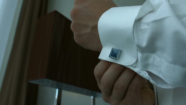 close up of a hand man how wears white shirt and cufflink