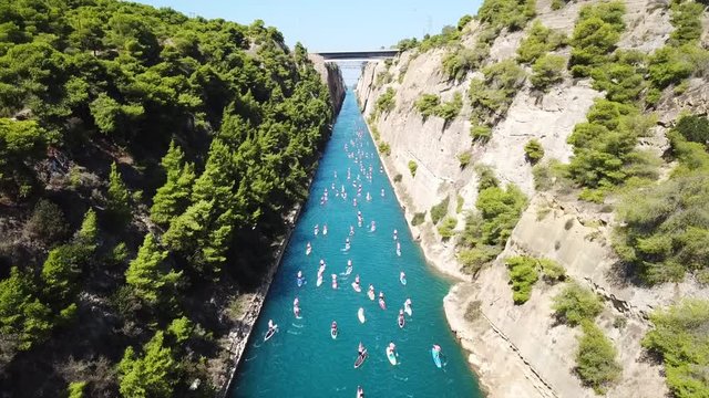 Aerial bird's eye view video taken by drone of stand up paddle surfing competition or SUP in Corinth Canal of Isthmos, Peloponnese, Greece