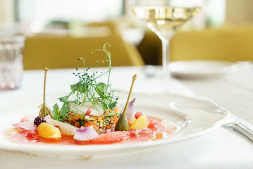 tuna carpaccio and white wine on the table in the restaurant