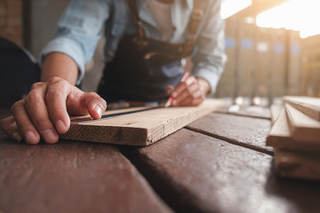 Carpenter working with equipment on wooden table in carpentry shop. woman works in a carpentry shop.