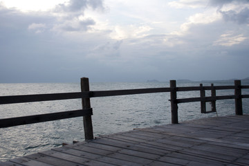 Seascape skyline during sunset behind wooden pier fence