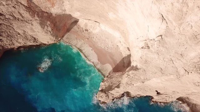 Aerial top view video of iconic Navagio or Shipwreck ship as seen from above in one of the most beautiful beaches in the world with deep turquoise clear sea, Zakynthos island, Ionian, Greece
