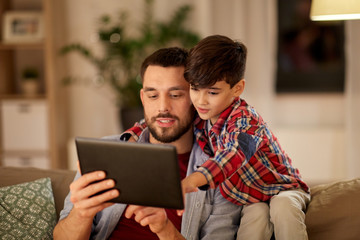 family, fatherhood, technology and people concept - happy father and little son with tablet pc...